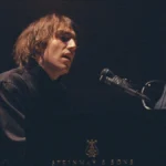 Cameron Winter singing at a Steinway grand piano in Cameron Winter at Carnegie Hall